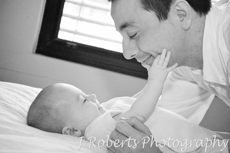 baby reaching up to touch dad's face - baby portrait photography sydney